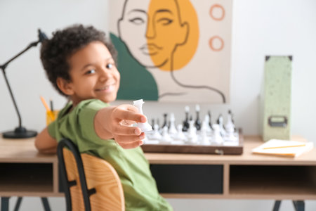 Cute African-American boy playing chess at homeの写真素材