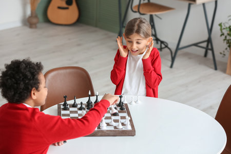 Cute children playing chess at homeの写真素材