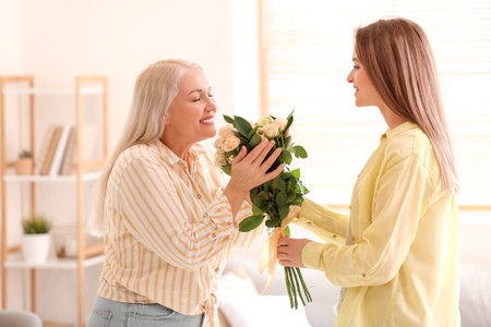 Young woman greeting her mom on Mother's Day at homeの写真素材