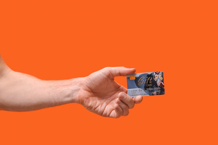Hand with gift card on color backgroundの写真素材