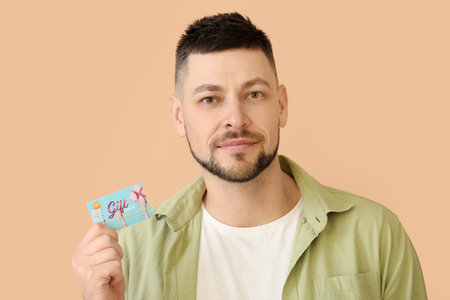 Handsome man with gift card on color background