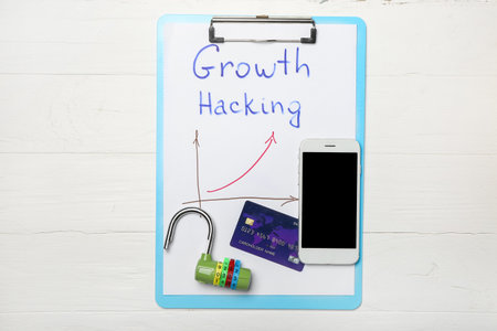 Clipboard with text GROWTH HACKING, credit card, phone and lock on white background