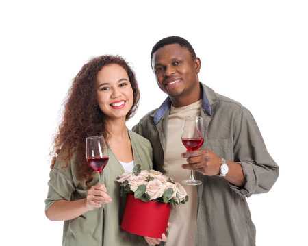 African-American couple with flowers and glasses of wine on white background. Valentine's Day celebrationの写真素材