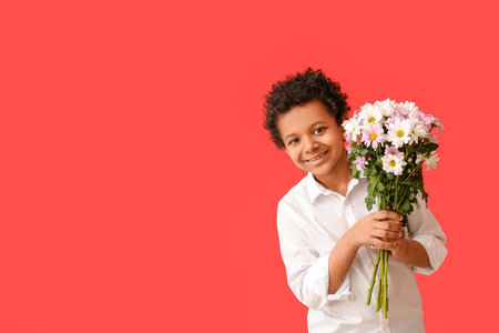 African-American boy with bouquet of beautiful flowers on color backgroundの写真素材