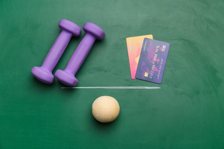 Dumbbells and credit cards on drawn scales on chalkboard. concept of balanceの写真素材