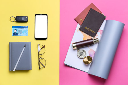 Notebook with mobile phone, car key and map with passports on color background. concept of balanceの写真素材