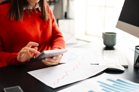Female accountant with calculator working in office, closeupの写真素材
