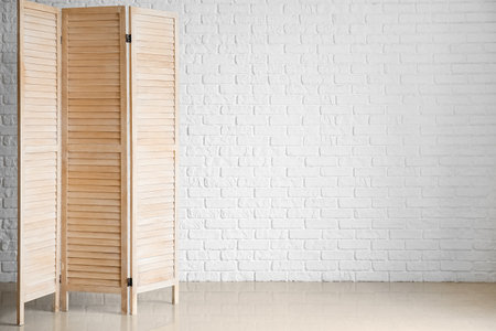 Wooden folding screen near white wallの写真素材