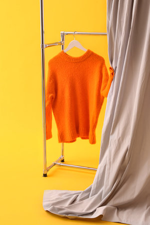 Stand with red sweater and cloth on yellow backgroundの写真素材