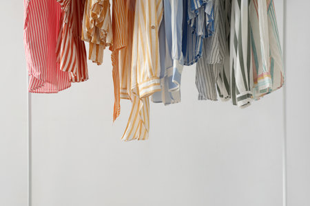 Rack with stylish female clothes near light wall, closeupの写真素材