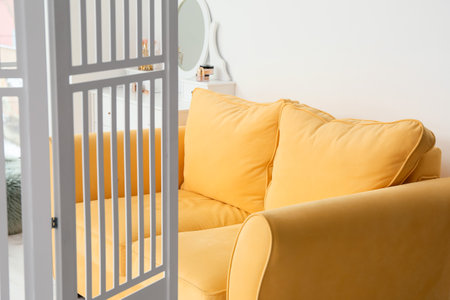 Cozy sofa and folding screen in room