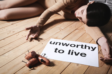 Young woman lying on floor near sausages with nails. concept of cruelty to animalsの写真素材