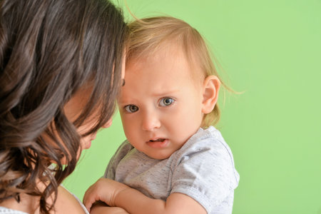 Happy woman and her little daughter on color backgroundの写真素材