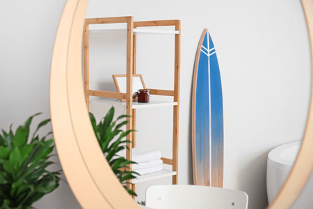 Interior of stylish bathroom with surfboard and mirrorの写真素材