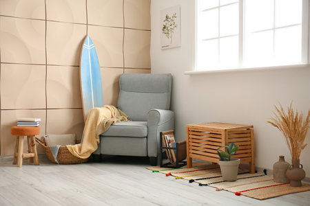 Interior of stylish modern room with surfboard and armchairの写真素材