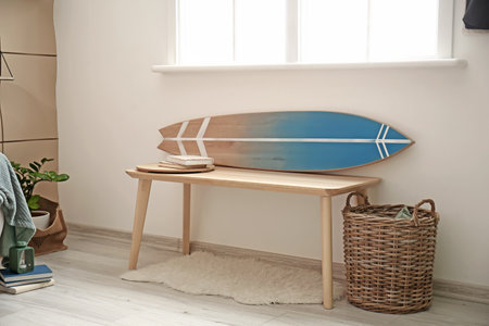 Bench with surfboard in interior of stylish modern room