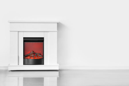 Stylish fireplace near white wall in living roomの写真素材