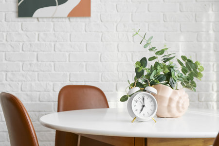 Alarm clock with floral decor on table in roomの写真素材