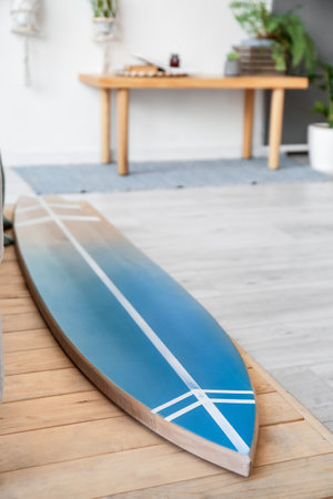 Wooden surfboard on floor in roomの写真素材