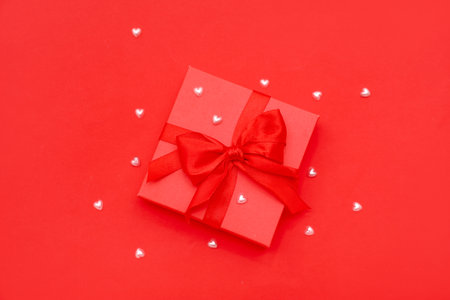 Gift box with beads on red background. valentine's day celebration