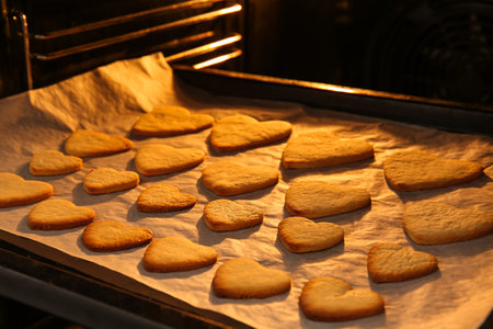 Baking tray with sweet heart shaped cookies in oven, closeup. valentine's day celebrationの写真素材