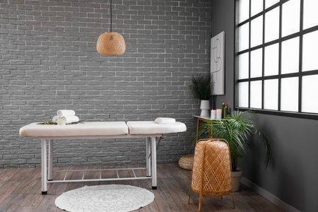 Interior of spa salon with couch, table and palm leavesの写真素材