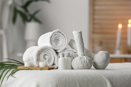 Spa composition with burning candles on couch in salon, closeup