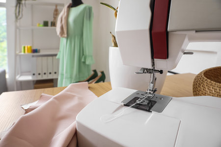 Modern sewing machine on table in atelier, closeup