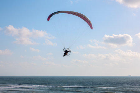Parachutist flying over sea on summer day
