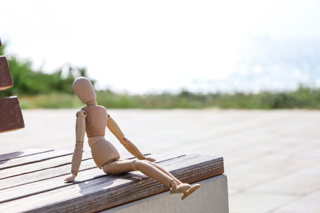 Wooden mannequin on bench at sea resort, closeupの写真素材