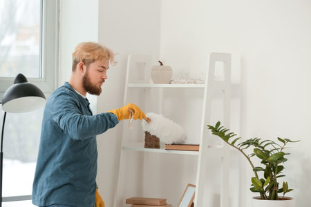 Young man cleaning his flat