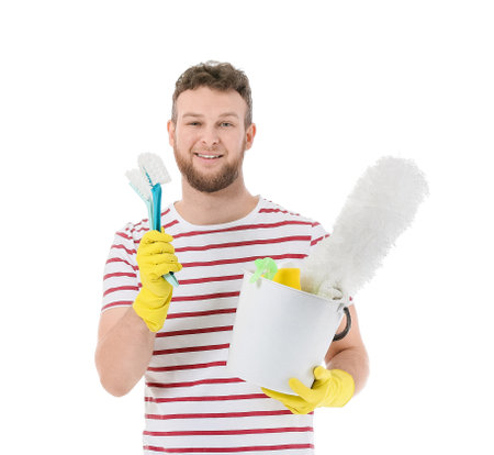 Young man with cleaning supplies on white backgroundの写真素材