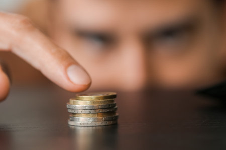 Man counting coins at table, closeup. bankruptcy conceptの写真素材