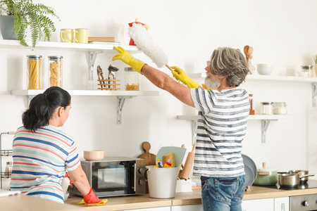 Mature couple cleaning their kitchenの写真素材