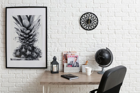 Modern workplace with organizers near brick wall