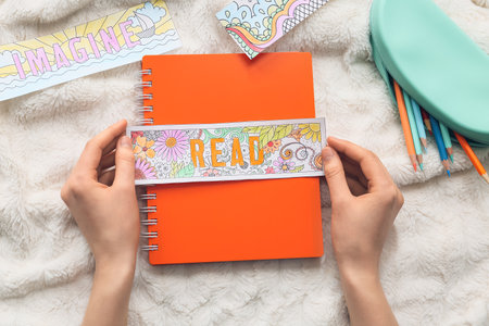 Woman with cute bookmarks and notebook on bedの写真素材