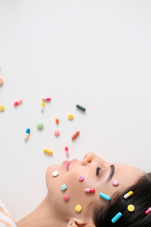 Beautiful woman with pills on light background, top viewの写真素材