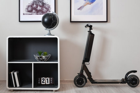 Stylish interior of minimalist room with electric scooter, shelf unit and decorの写真素材