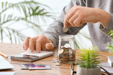 Businessman with calculator counting money at workplaceの写真素材