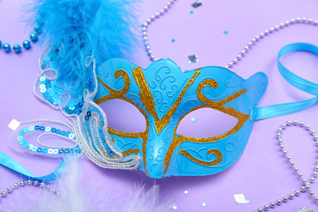 Carnival mask with beads and confetti on lilac backgroundの写真素材