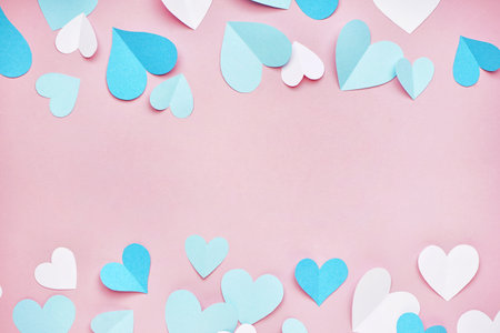 Composition with blue and white paper hearts on pink background. valentine's day celebration