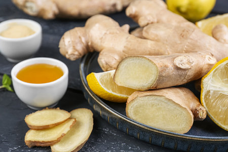 Plate with ginger roots, slices and honey on table, closeup
