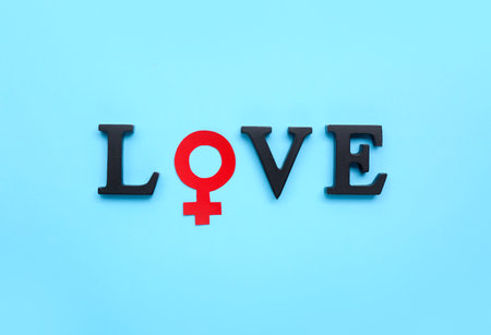 Word LOVE with symbol of woman on blue background. Valentine's Day celebrationの写真素材