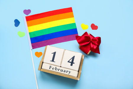 Cube calendar with date 14 FEBRUARY, gift, hearts and LGBT flag on blue backgroundの写真素材