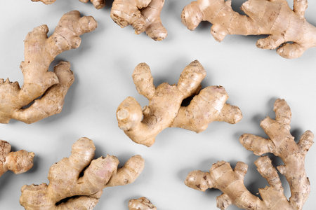 Fresh ginger roots on gray background, closeup