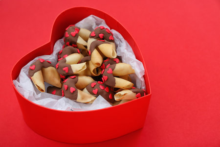 Box with tasty fortune cookies on red background. Valentine's Day celebrationの写真素材