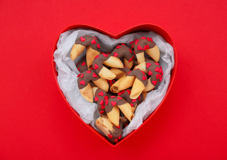 Box with tasty fortune cookies on red background. Valentine's Day celebrationの写真素材