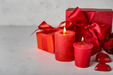 Burning candles and gift boxes on light background. Valentine's Day celebrationの写真素材