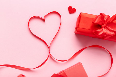 Heart made of ribbon and gifts on pink background. Valentine's Day celebrationの写真素材