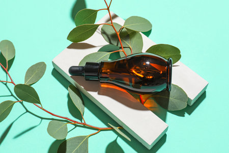 Composition with bottle of serum, eucalyptus branches and decor on color backgroundの写真素材